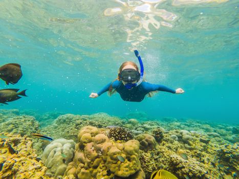 Happy woman in snorkeling mask dive underwater with tropical fishes in coral reef sea pool. Travel lifestyle, water sport outdoor adventure, swimming lessons on summer beach holiday.