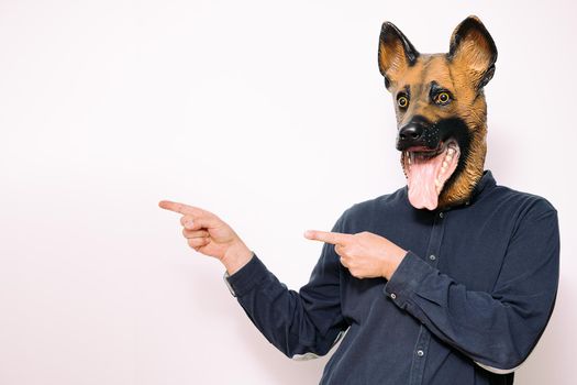 person with a dog mask pointing fingers at his side on white background, copy space for text