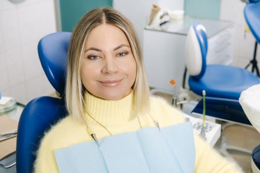 The girl smiles at the dentist and looks at her.