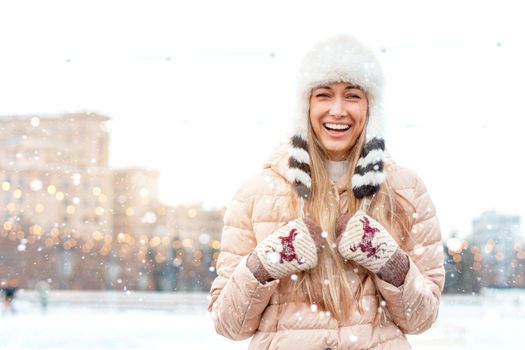 Happy winter time in big city charming girl standing street dressed funny fluffy hat. Enjoying snowfall, expressing positivity, smiling to camera, joyful cheerful mood, true emotions, Christmas mood