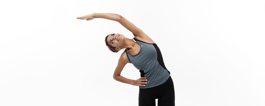 Sport, training, lifestyle and Fitness concept - portrait of beautiful happy African American woman stretching hands. Isolated on white studio background