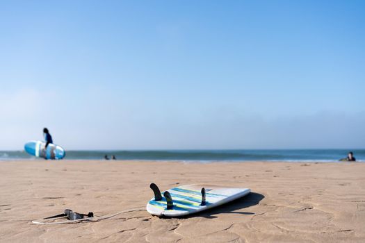 Serf board on the beach. View of nice Atlantic ocean beach with sand ,blue sea and blue sky. Holiday and vacation concept. Portugal Carcavelos