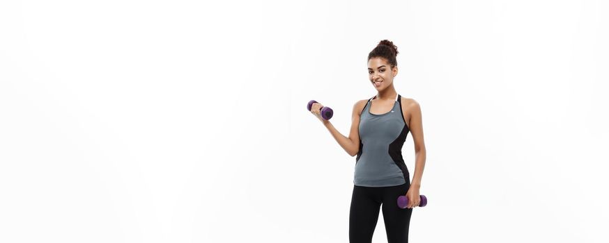 Healthy and Fitness concept - Full-length of portrait Beautiful American African lady in grey fitness clothes workout with dumbbell. Isolated on white background