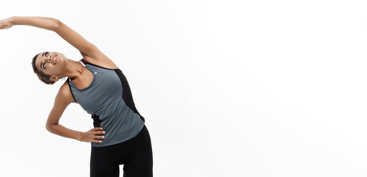 Sport, training, lifestyle and Fitness concept - portrait of beautiful happy African American woman stretching hands. Isolated on white studio background