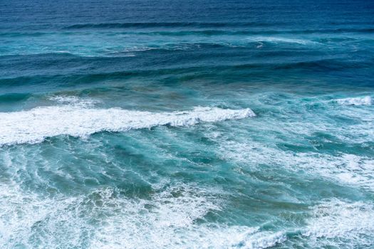 Aerial view of tropical sandy beach and ocean with turquoise water with waves. Sunny day on Atlantic ocean beach in Portugal