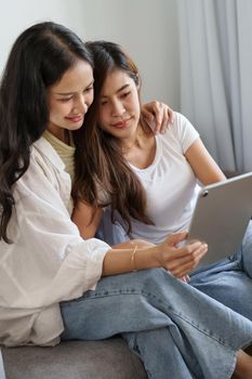 lgbtq or lgbt concept, homosexuality, two asian women enjoying together and showing love for each other while using tablet.