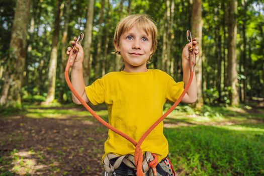 Little boy in a rope park. Active physical recreation of the child in the fresh air in the park. Training for children.