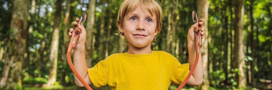 Little boy in a rope park. Active physical recreation of the child in the fresh air in the park. Training for children. BANNER, LONG FORMAT