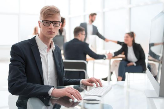 confident young employee in the workplace in the office. people and technology