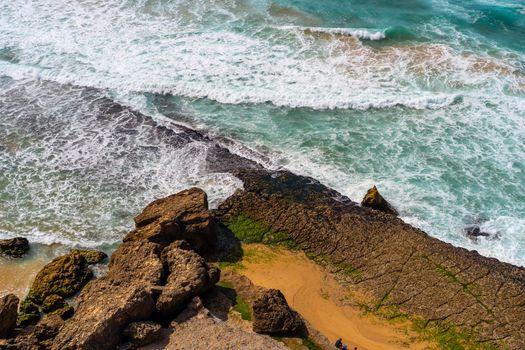 Aerial view of tropical sandy beach and ocean with turquoise water with waves. Sunny day on Atlantic ocean beach in Portugal