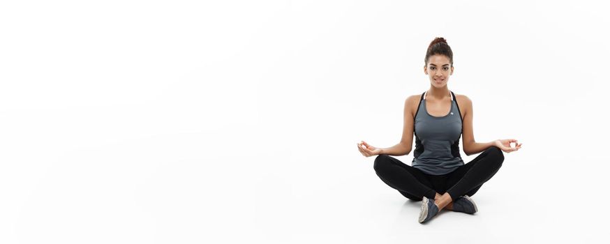 Healthy and Fitness concept - Beautiful American African lady in fitness clothing doing yoga and meditation. Isolated on white background