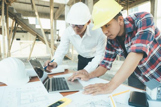 The engineering team working at building site meeting and discussing on laptop . Team onsite of architecture inspector and discuss together