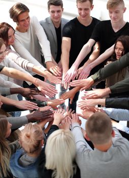 close up. a group of diverse people joining their hands in a circle.