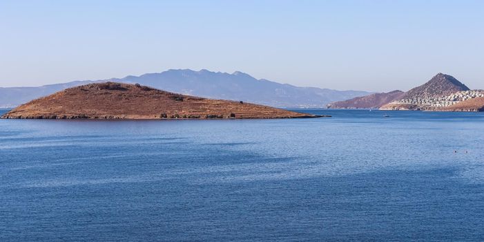 Sea, mountains and blue sky. Tranquil seascape and coastal nature background