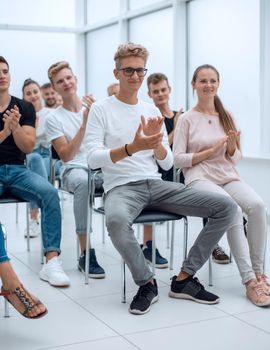 group of young people applaud at a group meeting. business and education