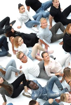 top view. group of young people sitting on the floor and looking at the camera.