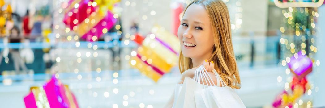 Young woman in Christmas mall with Christmas shopping. Beauty buy Christmas night shopping discounts. BANNER, LONG FORMAT