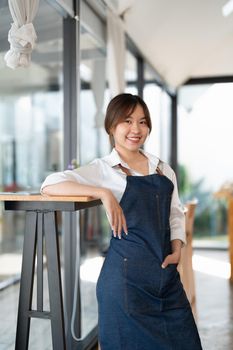 Portrait of woman barista startup successful small Asian business owner in coffee shop.Asian woman barista cafe owner. SME entrepreneur seller business concept.