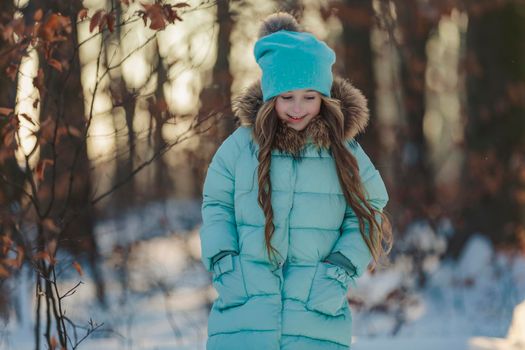 happy girl in turquoise jacket and hat