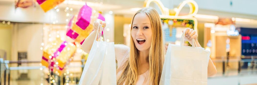 Young woman with purchases in new year shop. Christmas sale, black friday. BANNER, LONG FORMAT