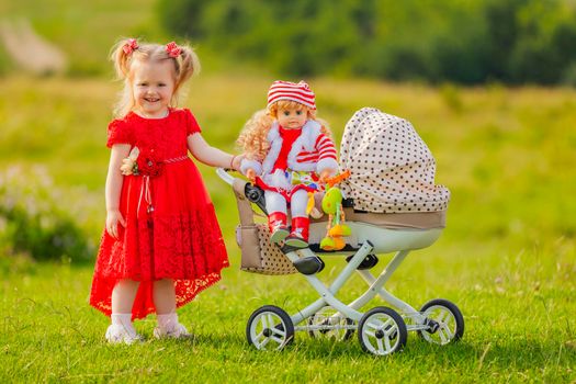 a girl rolls her doll on a toy stroller