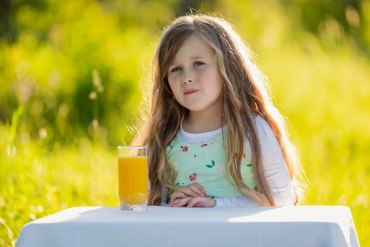 girl with a glass of orange juice in nature