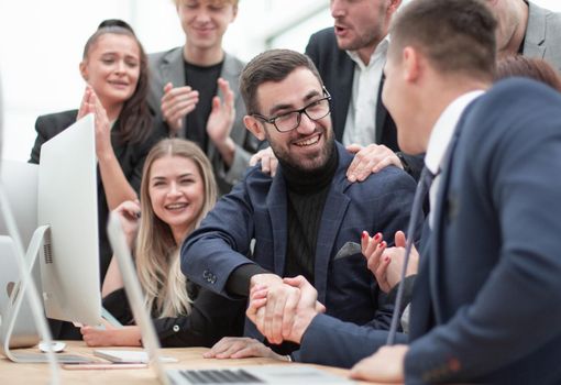 happy business colleagues shaking hands with each other. success concept