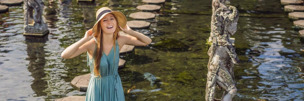 Young woman tourist in Taman Tirtagangga, Water palace, Water park, Bali Indonesia. BANNER, LONG FORMAT