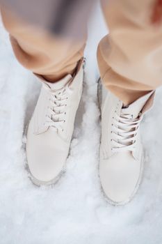 The model demonstrates women's shoes in the snow