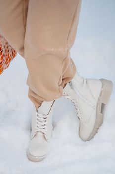 The model demonstrates women's shoes in the snow