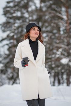 A model girl walking through a snow-covered forest, a demonstration of clothes