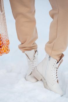 The model demonstrates women's shoes in the snow