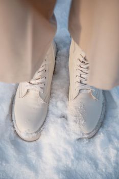 The model demonstrates women's shoes in the snow