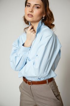 A girl in a blue shirt and trousers. Shooting fashion clothes.