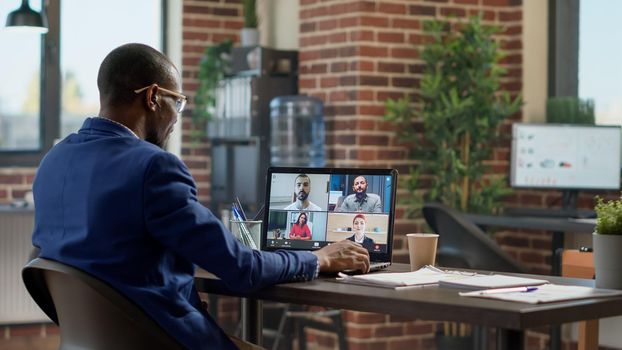 Multiethnic group of people talking on remote video call conference in company office, doing online business meeting. Chatting on video teleconference for internet telework conversation.