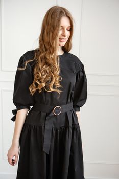 Fashion Portrait of Beautiful Model Girl wearing Black Dress.