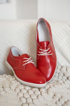 Red shoes with white laces, which are on a white knitted scarf