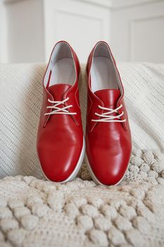 Red shoes with white laces, which are on a white knitted scarf