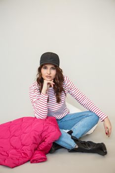 A girl model in pink clothes in the studio. Shooting fashionable clothes for the showroom.