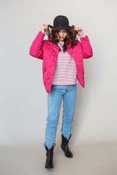 A girl model in pink clothes in the studio. Shooting fashionable clothes for the showroom.