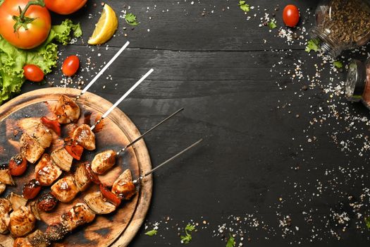 Grilled meat and vegetables on wooden background. Top view with copy space.