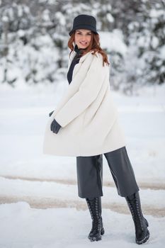 A model girl walking through a snow-covered forest, a demonstration of clothes