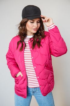 A girl model in pink clothes in the studio. Shooting fashionable clothes for the showroom.