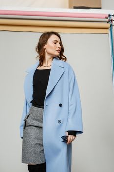 Beautiful brunette woman in a blue coat and nice top. Fashion spring autumn winter photo.