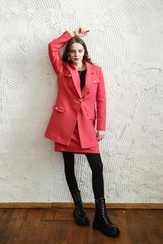 A girl model in pink clothes in the studio. Shooting fashionable clothes for the showroom.