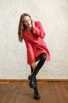 A girl model in pink clothes in the studio. Shooting fashionable clothes for the showroom.