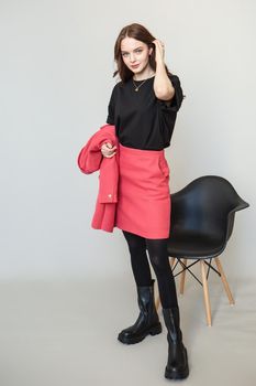 A girl model in pink clothes in the studio. Shooting fashionable clothes for the showroom.