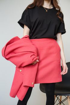 A girl model in pink clothes in the studio. Shooting fashionable clothes for the showroom.