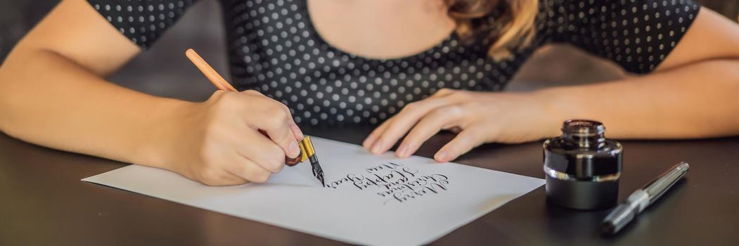 BANNER, LONG FORMAT Merry christmas and a happy new year. Calligrapher Young Woman writes phrase on white paper. Inscribing ornamental decorated letters. Calligraphy, graphic design, lettering, handwriting, creation concept.