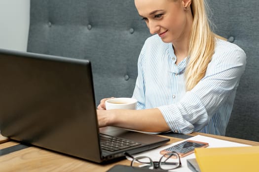 Young woman is using laptop during online learning at home office.